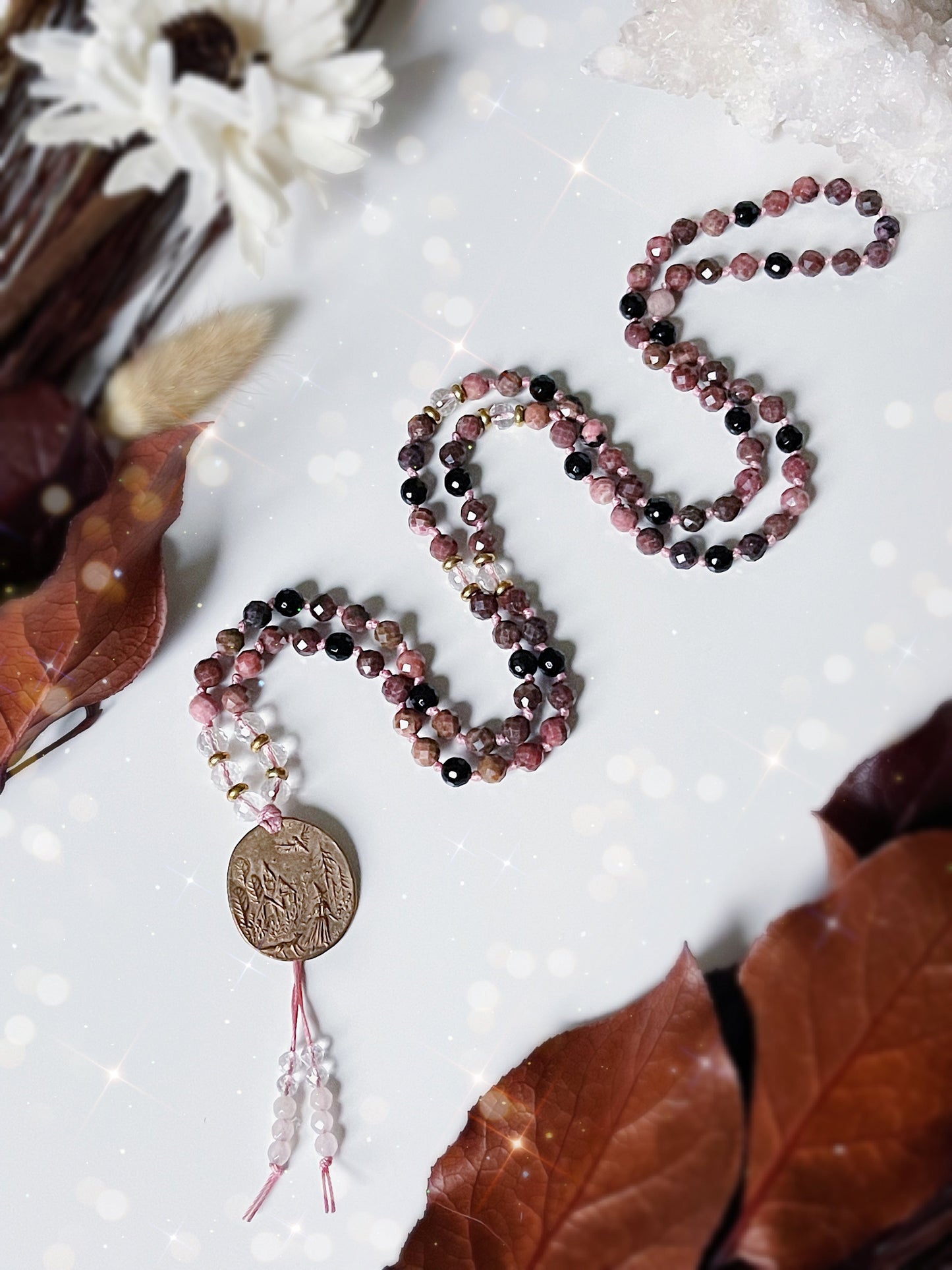 Bewitched Mala Necklace. 108 6mm beads of Rhodonite, Black Tourmaline, Clear Quartz and finished with a Bronze pendant of a witch in the woods. Available at The Crystalline Moon.